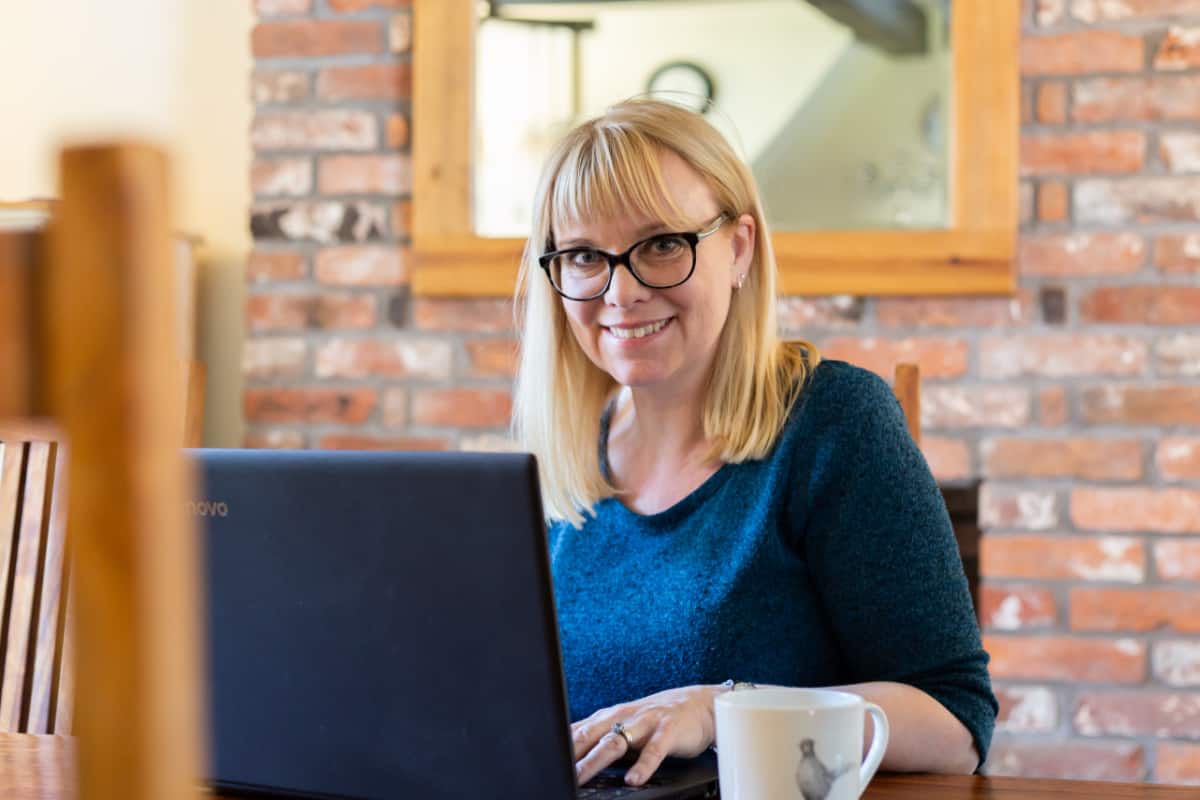 Imogen Allen of Umbrella Digital Media sitting at the table with laptop